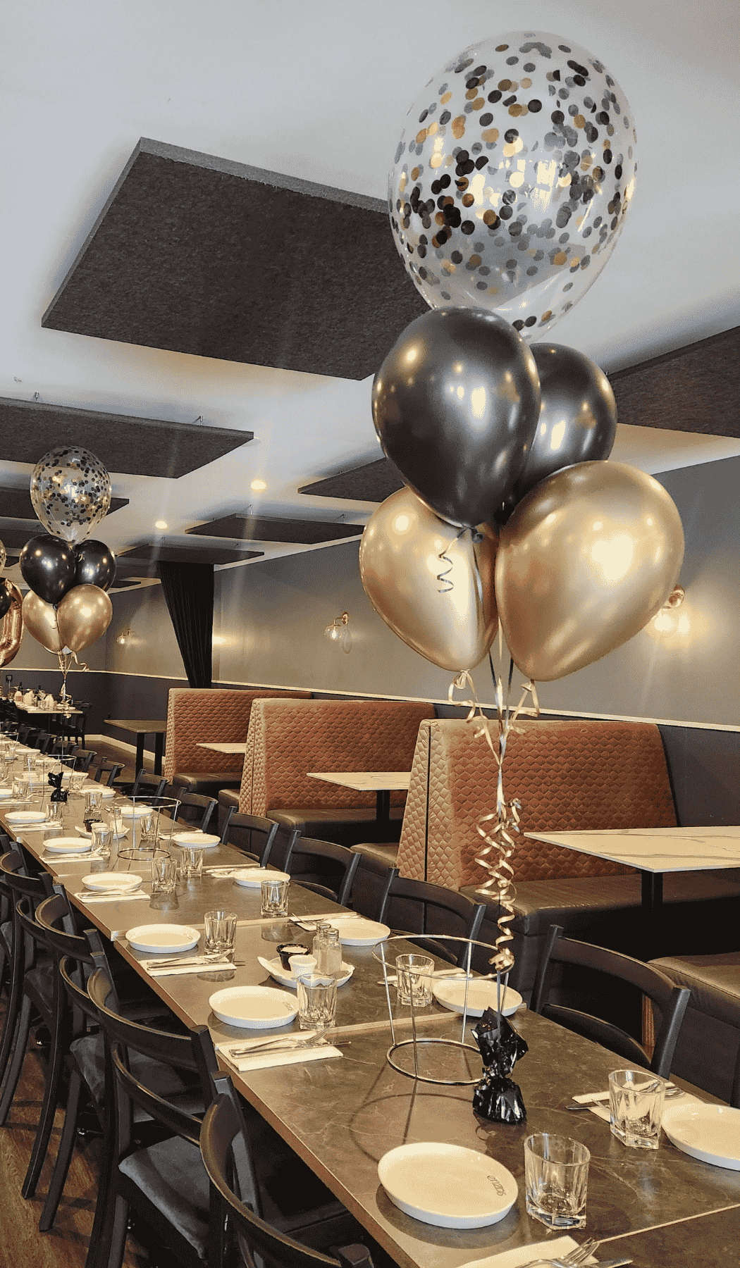 Helium bouquet with four plain latex balloons in gold and black and one confetti filled balloon on top
